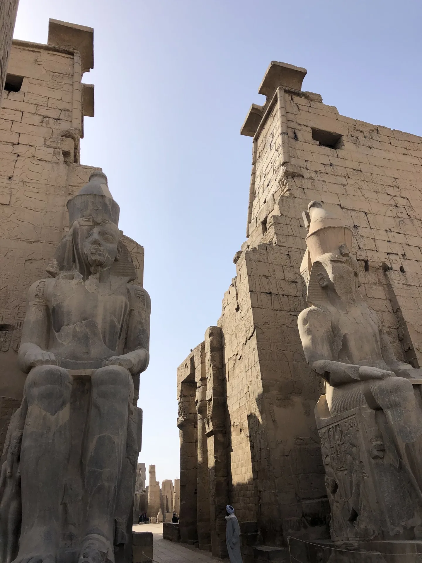 Large seated stone statues flanking an ancient temple entrance